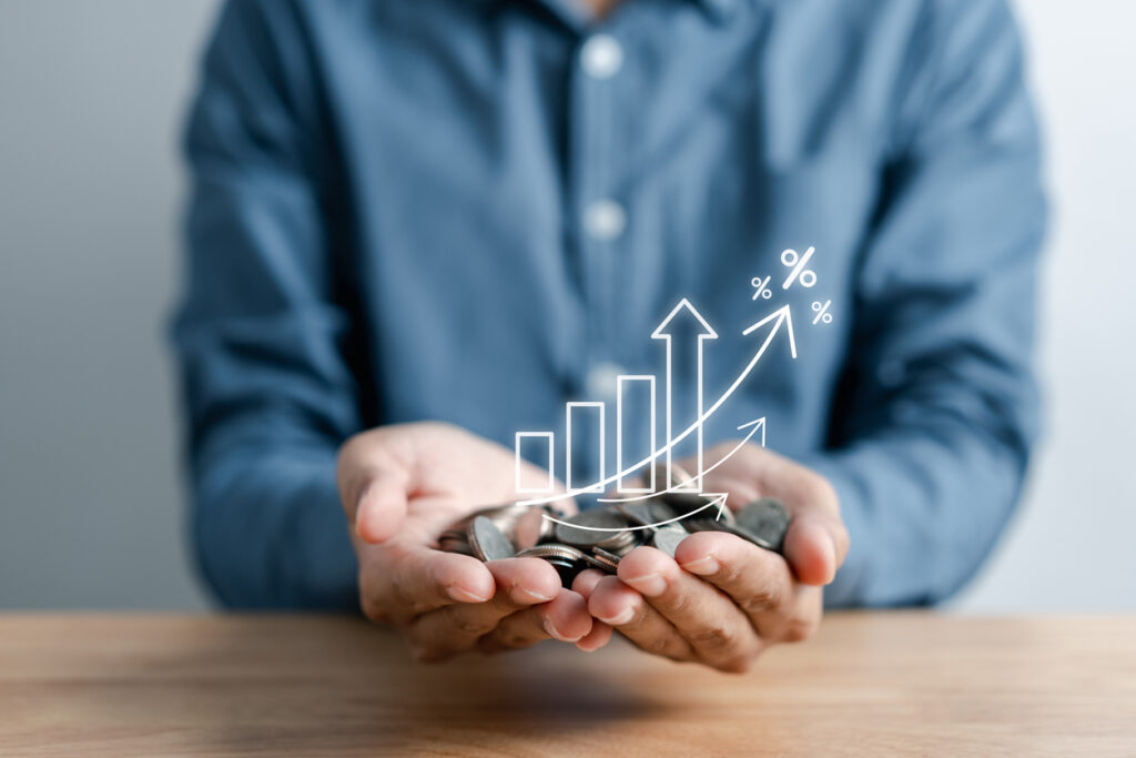 Hands holding graphic of chart going up with coins